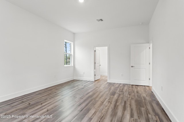 unfurnished bedroom featuring visible vents, baseboards, and wood finished floors