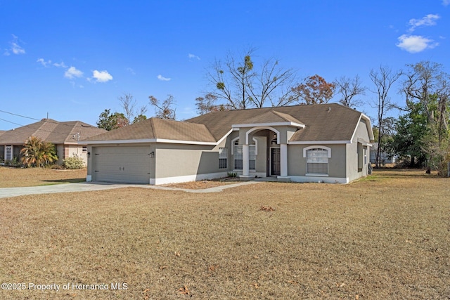 ranch-style house with a garage, a front yard, concrete driveway, and stucco siding