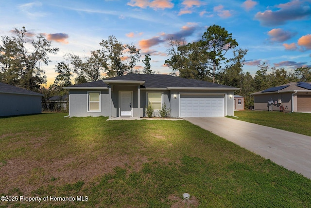 ranch-style home with a garage, stucco siding, a lawn, and concrete driveway