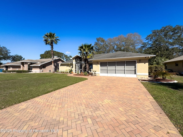 single story home featuring an attached garage, stucco siding, decorative driveway, and a front yard