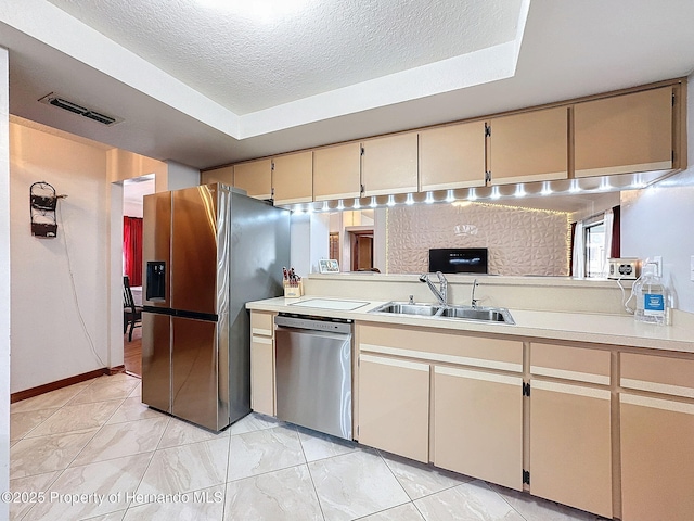 kitchen featuring stainless steel appliances, light countertops, visible vents, a sink, and a textured ceiling