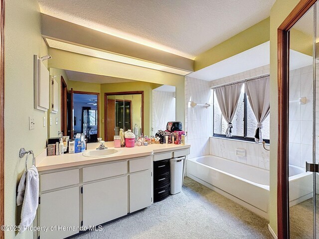 full bath with a textured ceiling and vanity