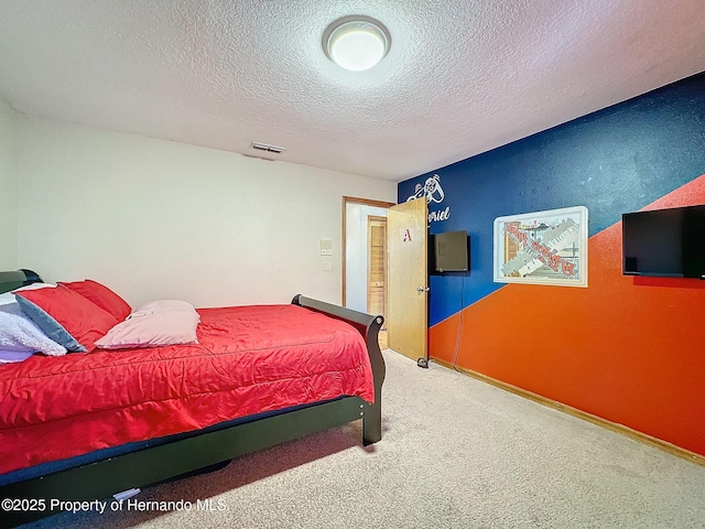 bedroom with carpet floors, visible vents, and a textured ceiling