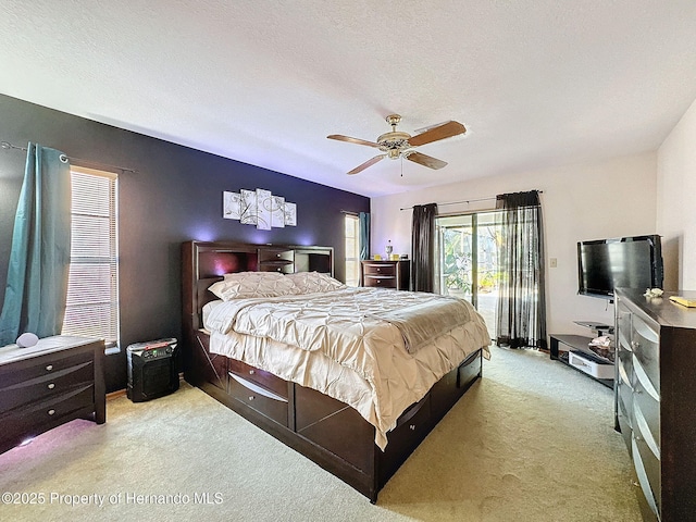 bedroom featuring access to exterior, light carpet, a textured ceiling, and a ceiling fan