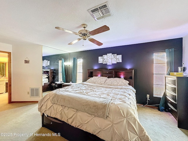 bedroom with baseboards, visible vents, a textured ceiling, and light colored carpet