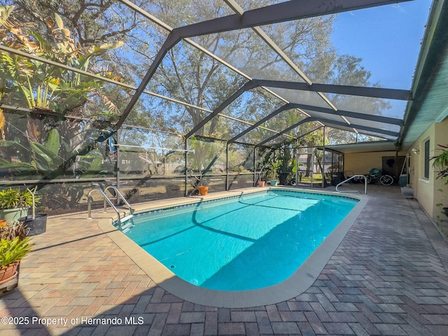 outdoor pool with a patio area and glass enclosure