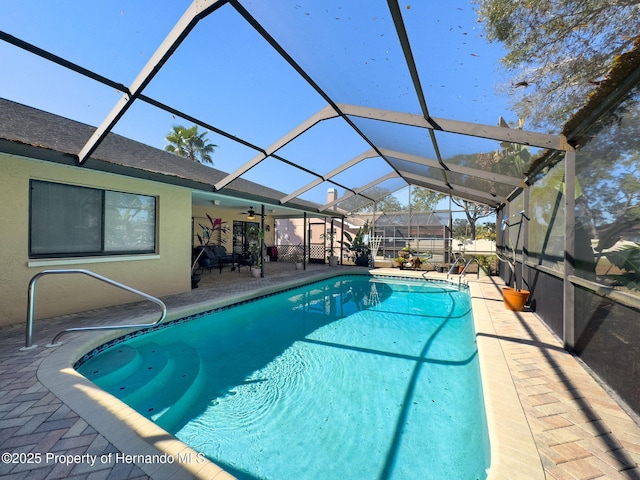 outdoor pool featuring a ceiling fan, a lanai, and a patio