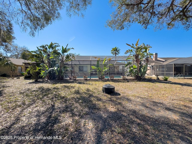 view of yard with glass enclosure and an outdoor pool