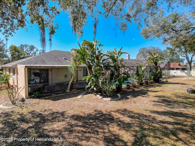 back of property with a residential view, a lawn, fence, and stucco siding