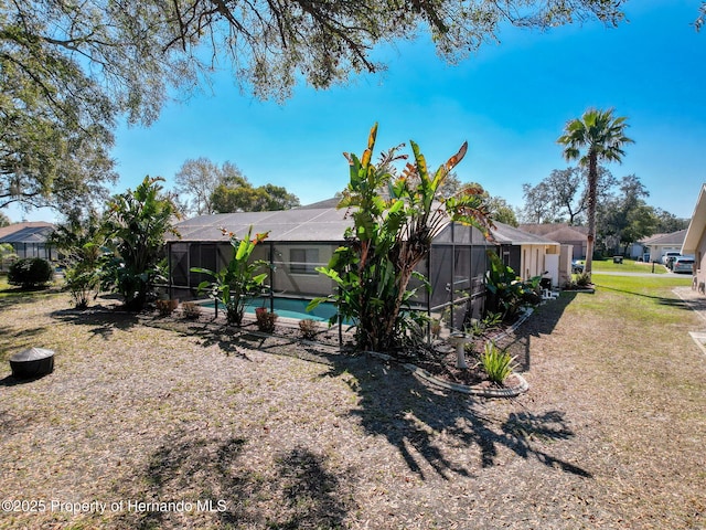 exterior space featuring a residential view, a lanai, an outdoor pool, and a lawn