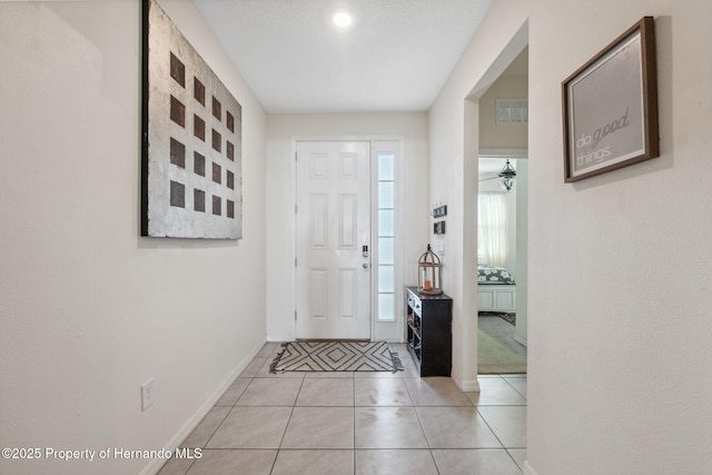 foyer featuring baseboards and light tile patterned flooring