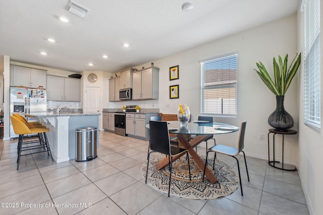 dining room featuring light tile patterned floors, baseboards, visible vents, and recessed lighting