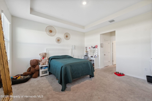 bedroom featuring carpet, visible vents, and a tray ceiling