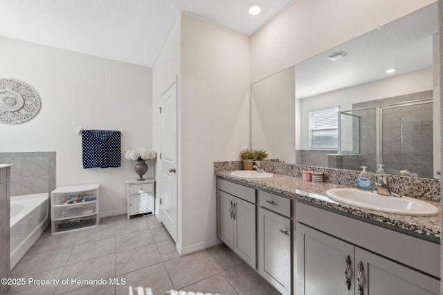 bathroom with a garden tub, a sink, a shower stall, tile patterned floors, and double vanity