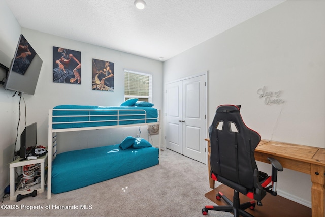 bedroom featuring a closet, a textured ceiling, and carpet flooring