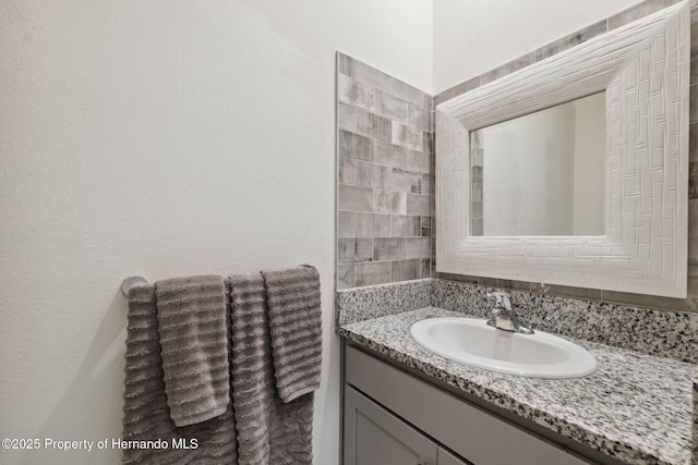 bathroom with a textured wall and vanity