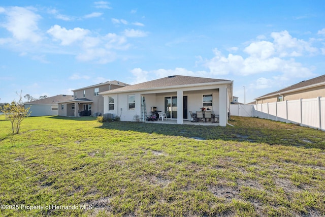 back of property with central air condition unit, stucco siding, a lawn, a patio area, and a fenced backyard