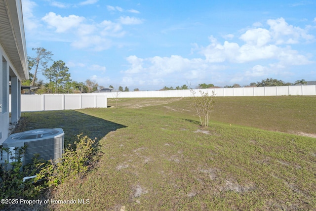 view of yard with a fenced backyard and central air condition unit