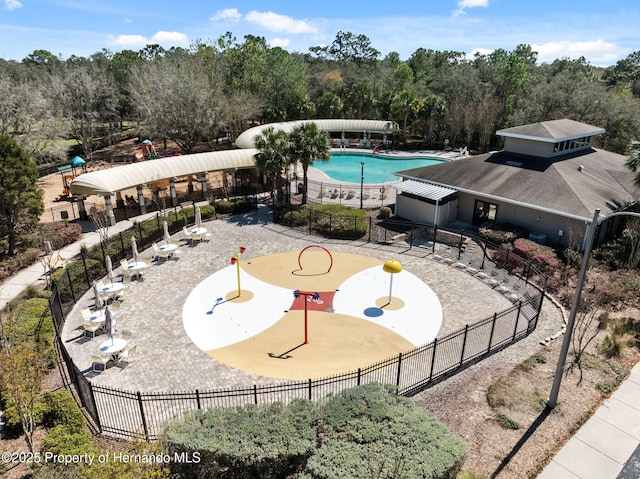 community pool with a patio and fence