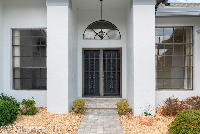 view of exterior entry with french doors and stucco siding