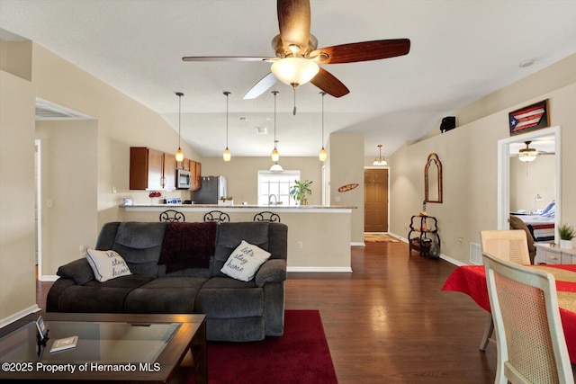 living area with vaulted ceiling, baseboards, dark wood-type flooring, and ceiling fan