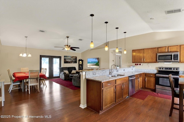 kitchen with a sink, stainless steel appliances, brown cabinets, and visible vents