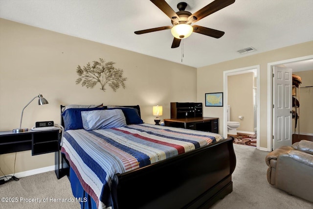 carpeted bedroom with ensuite bath, baseboards, visible vents, and a closet