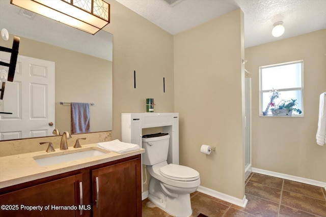 bathroom featuring vanity, visible vents, baseboards, a shower stall, and toilet