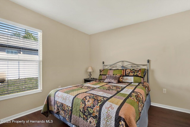 bedroom with baseboards and wood finished floors