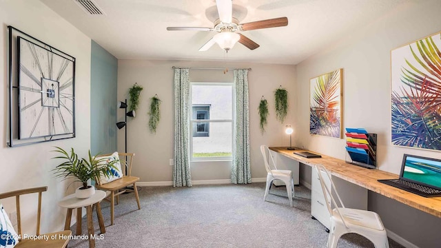 home office featuring ceiling fan, light colored carpet, visible vents, baseboards, and built in desk