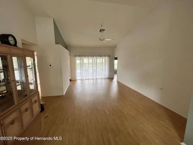 7441 Baywood Forest Cir, Spring Hill, FL 34606 - empty room with light wood finished floors, a ceiling fan, and high vaulted ceiling