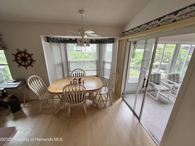 7441 Baywood Forest Cir, Spring Hill, FL 34606 - dining area with light wood finished floors, a textured ceiling, french doors, a ceiling fan, and lofted ceiling