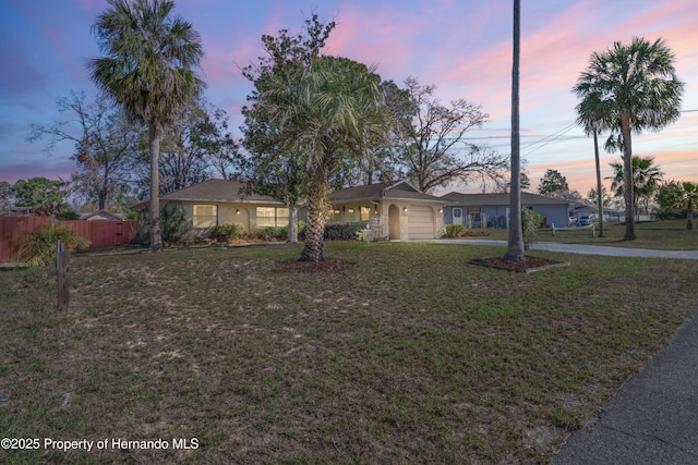 view of front of house featuring a garage, a front yard, fence, and driveway