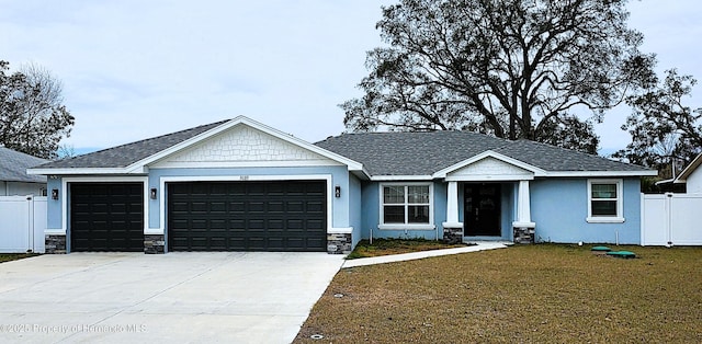 view of front of home featuring a garage, concrete driveway, a front yard, and fence