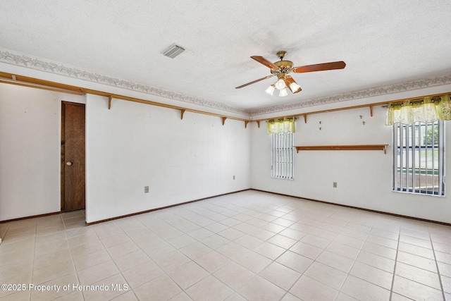 unfurnished room with visible vents, ceiling fan, a textured ceiling, and light tile patterned flooring