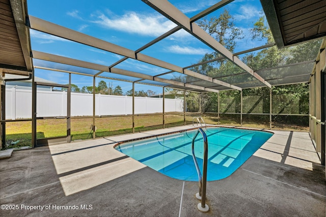 pool with glass enclosure, a fenced backyard, a yard, and a patio