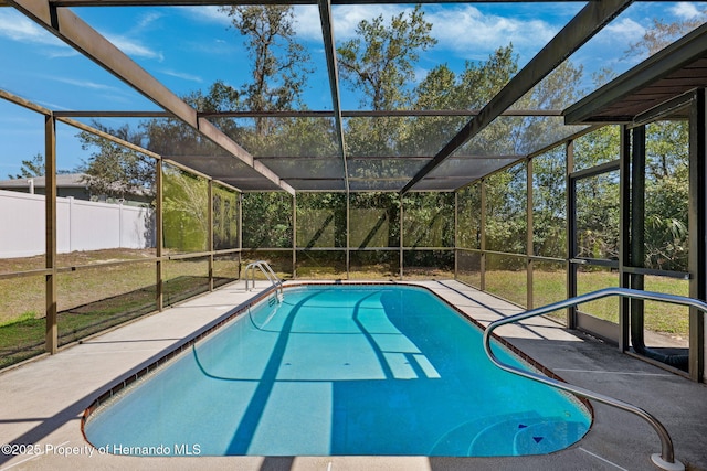 outdoor pool featuring a patio area, glass enclosure, and fence