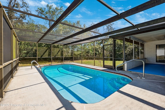 pool with a patio and glass enclosure