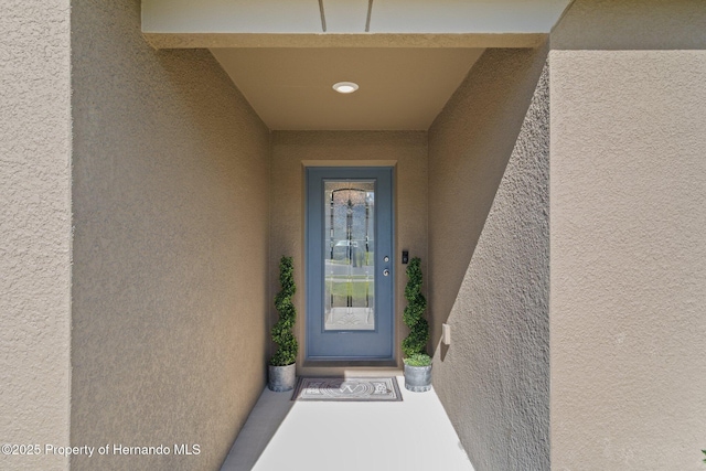 doorway to property featuring stucco siding