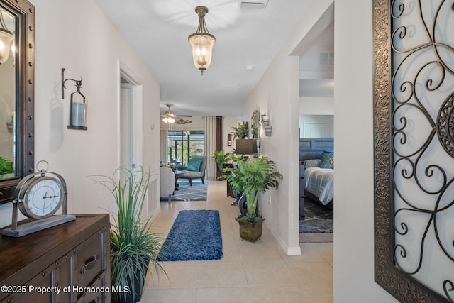 foyer with light tile patterned floors, baseboards, visible vents, and a ceiling fan