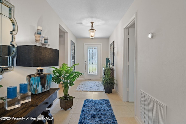 tiled foyer entrance with visible vents and baseboards