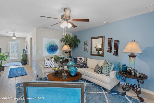 living room featuring visible vents, ceiling fan, baseboards, and tile patterned floors