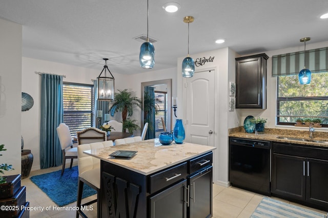 kitchen with visible vents, dishwasher, a sink, and light stone countertops