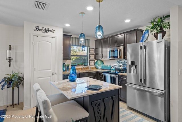 kitchen featuring appliances with stainless steel finishes, light tile patterned flooring, visible vents, and light stone countertops