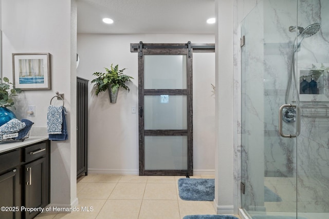 bathroom featuring a marble finish shower, baseboards, tile patterned flooring, vanity, and recessed lighting