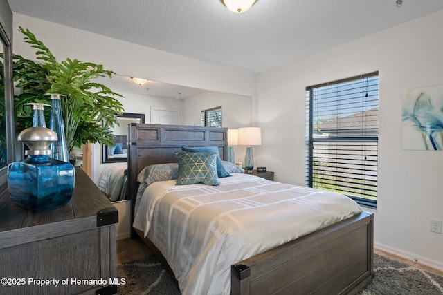 bedroom featuring baseboards and a textured ceiling