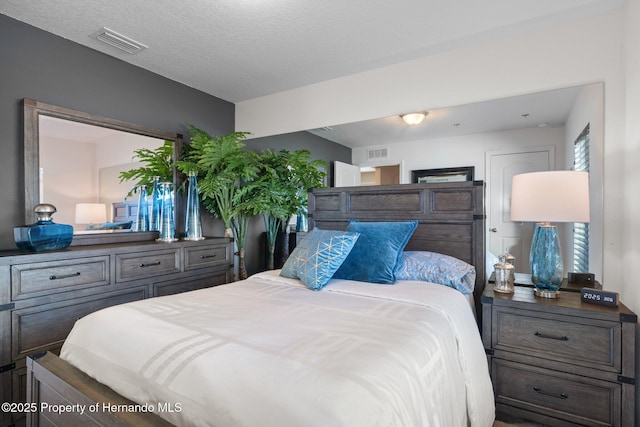 bedroom with visible vents and a textured ceiling