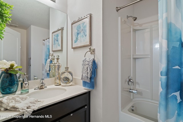 bathroom featuring a textured ceiling, shower / tub combo with curtain, and vanity