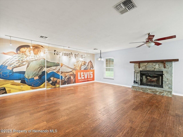 interior space with visible vents, wood finished floors, and a stone fireplace