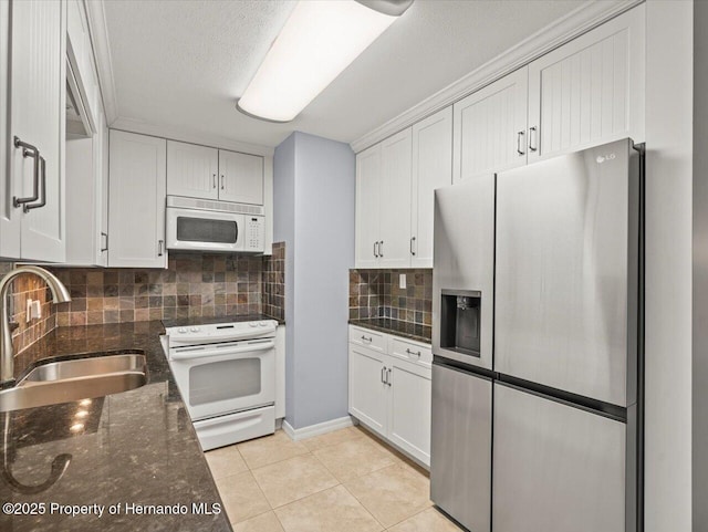 kitchen with light tile patterned floors, white appliances, a sink, white cabinetry, and decorative backsplash